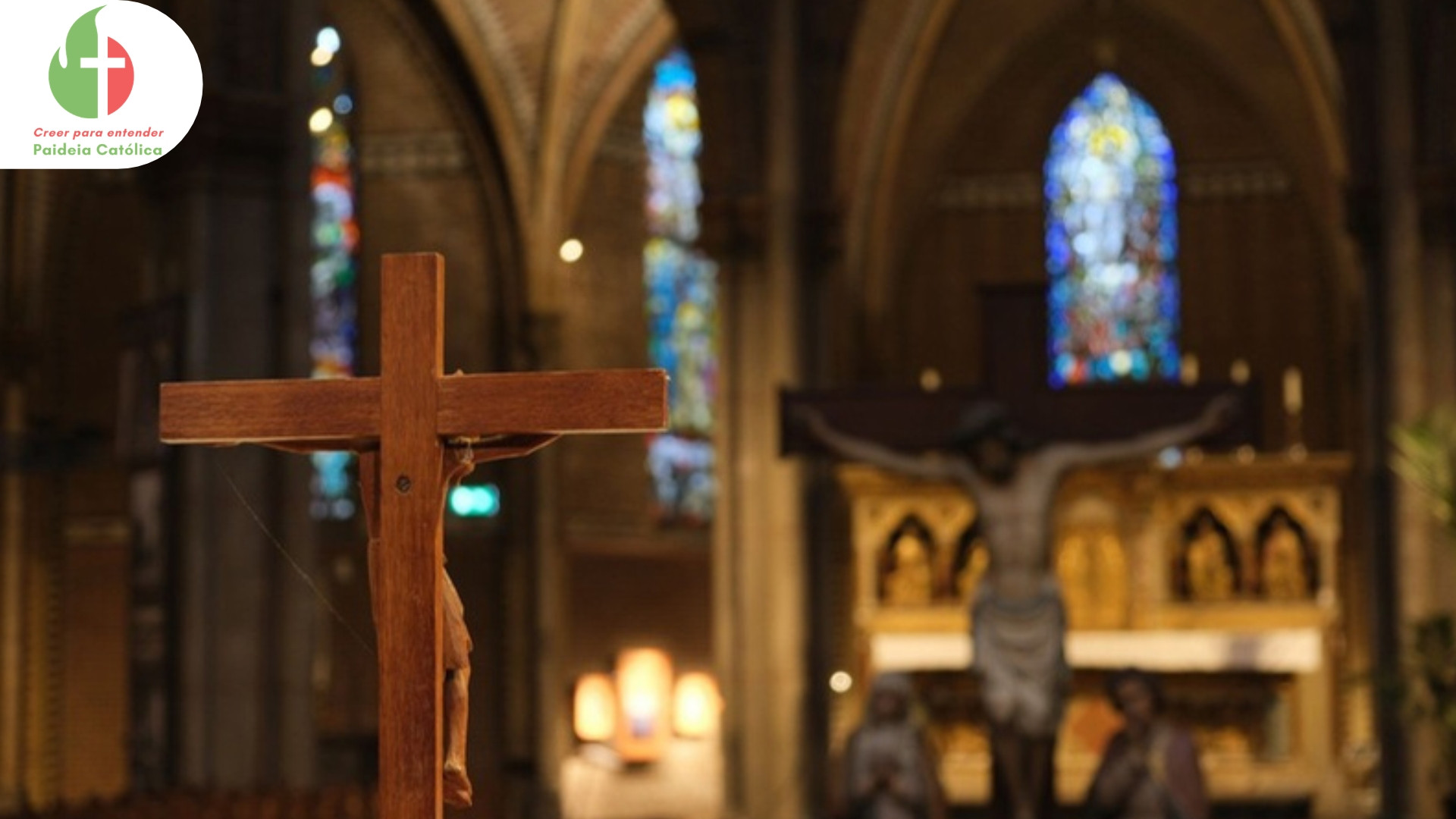 Crucifijo de madera en primer plano dentro de una iglesia, con el altar al fondo